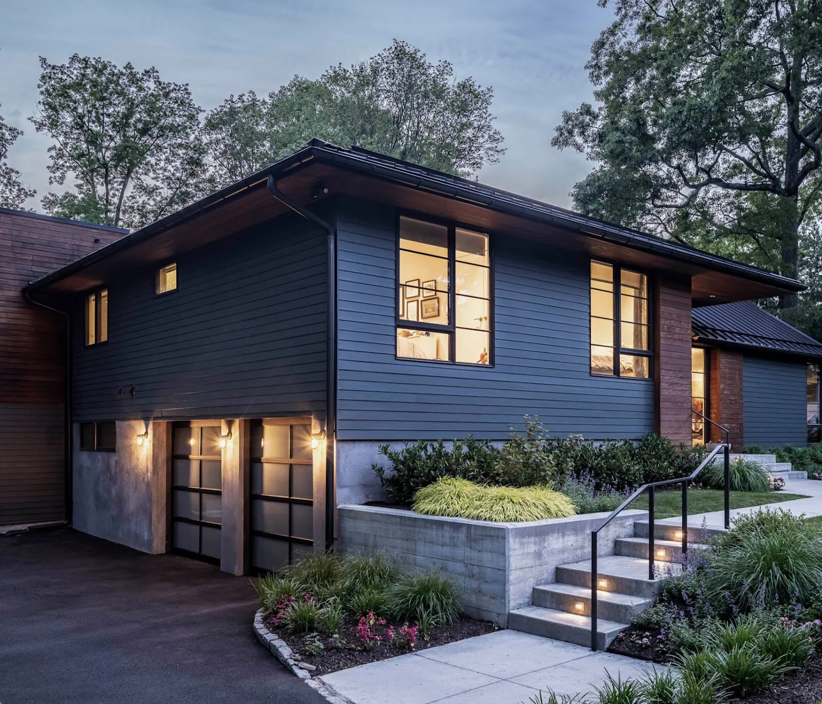 Midcentury modern split-level home with James Hardie HardiePlank in Iron Gray at dusk